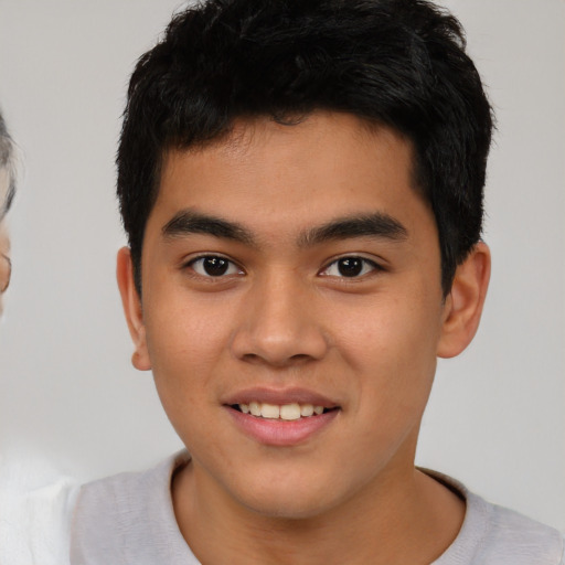 Joyful asian young-adult male with short  brown hair and brown eyes