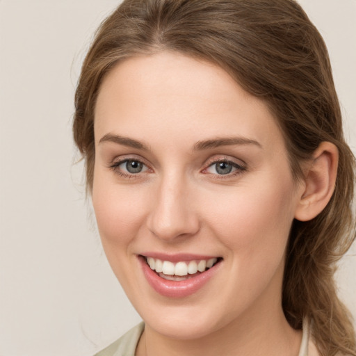 Joyful white young-adult female with long  brown hair and grey eyes