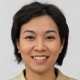 Joyful asian young-adult female with medium  brown hair and brown eyes