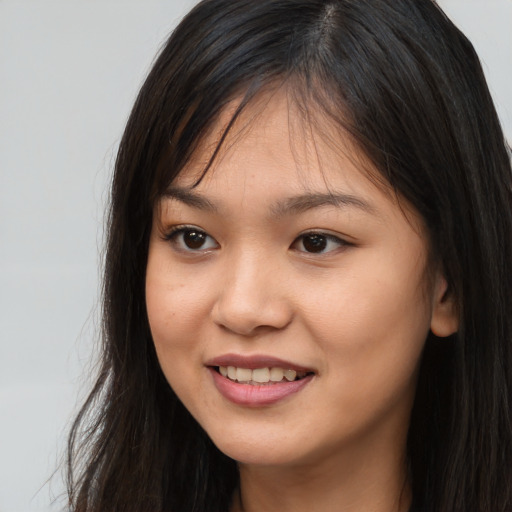 Joyful asian young-adult female with long  brown hair and brown eyes