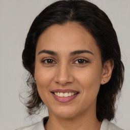 Joyful latino young-adult female with medium  brown hair and brown eyes