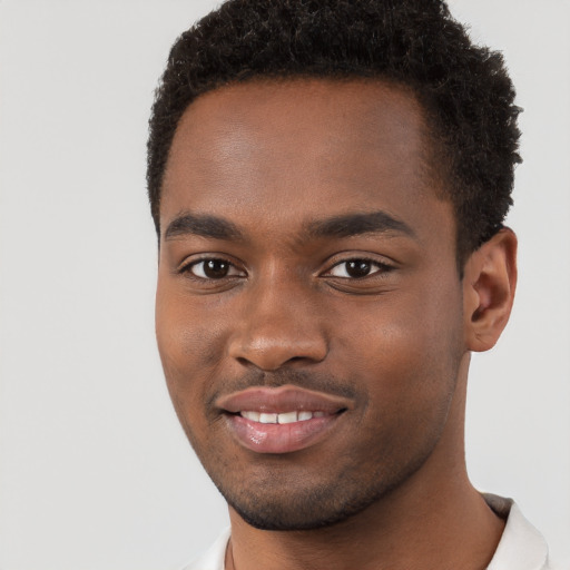 Joyful black young-adult male with short  brown hair and brown eyes