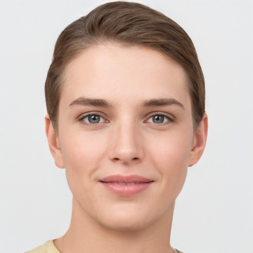 Joyful white young-adult female with short  brown hair and grey eyes