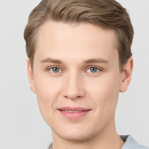 Joyful white young-adult male with short  brown hair and grey eyes