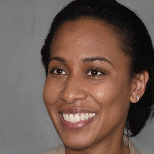 Joyful black adult female with short  brown hair and brown eyes