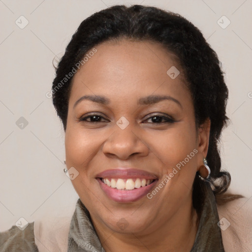 Joyful black adult female with long  brown hair and brown eyes