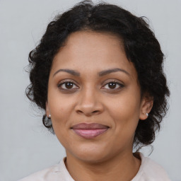 Joyful black adult female with medium  brown hair and brown eyes