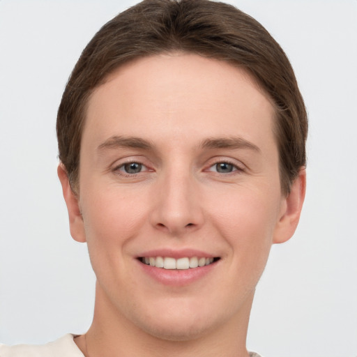 Joyful white young-adult female with short  brown hair and grey eyes