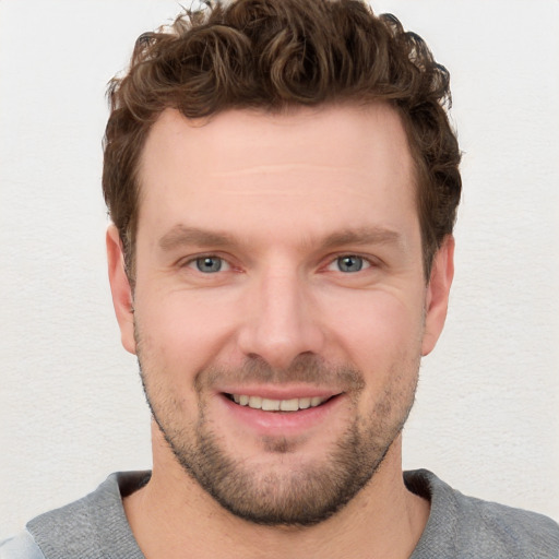 Joyful white young-adult male with short  brown hair and blue eyes