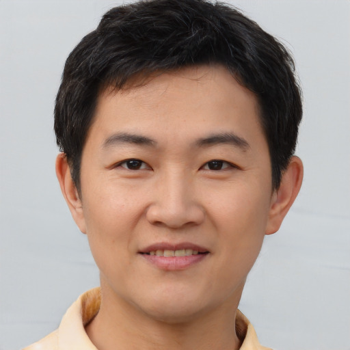 Joyful asian young-adult male with short  brown hair and brown eyes