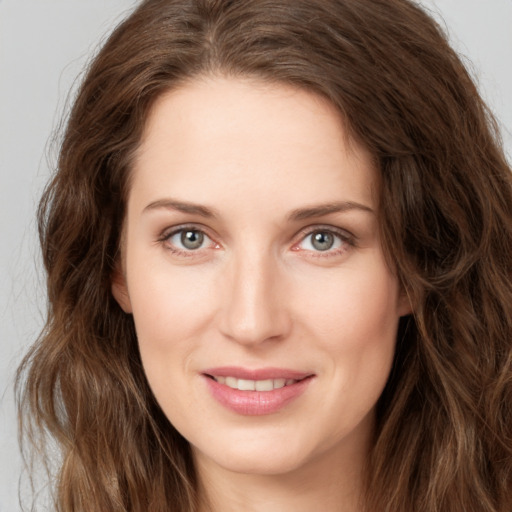 Joyful white young-adult female with long  brown hair and green eyes