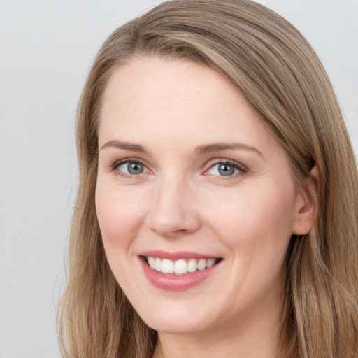 Joyful white young-adult female with long  brown hair and grey eyes