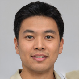 Joyful asian young-adult male with short  brown hair and brown eyes