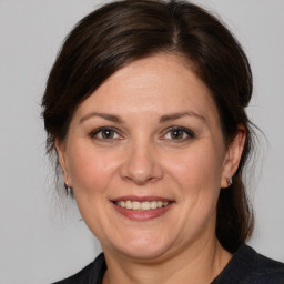 Joyful white adult female with medium  brown hair and brown eyes