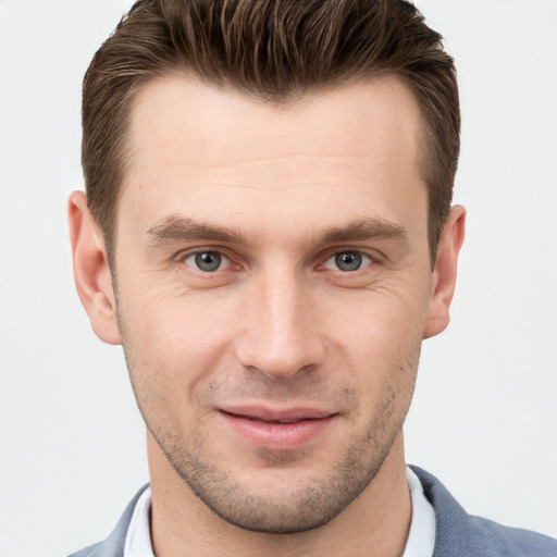 Joyful white young-adult male with short  brown hair and grey eyes