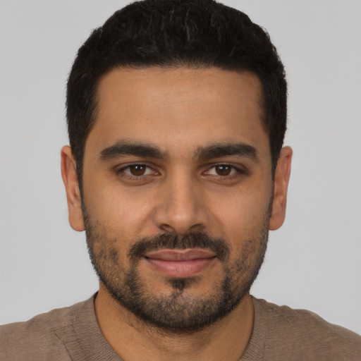 Joyful latino young-adult male with short  black hair and brown eyes