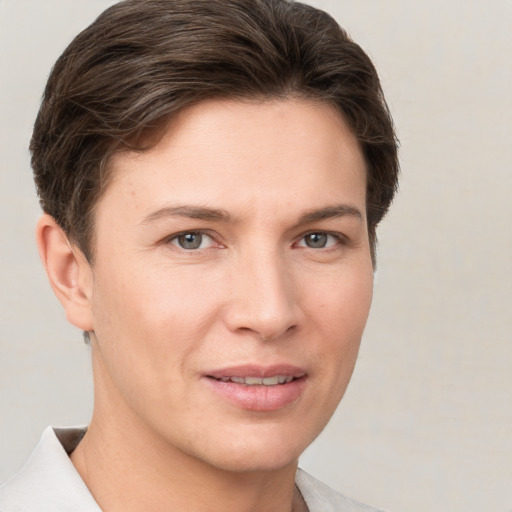 Joyful white young-adult female with short  brown hair and grey eyes