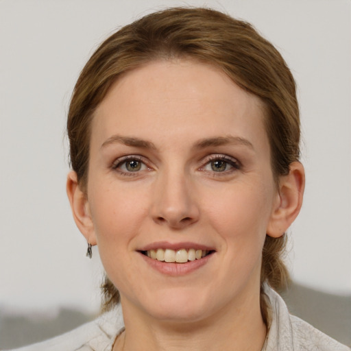 Joyful white young-adult female with medium  brown hair and grey eyes