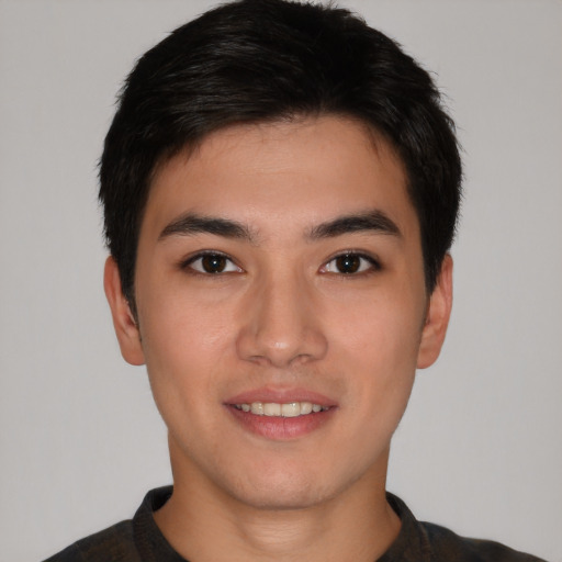 Joyful asian young-adult male with short  black hair and brown eyes