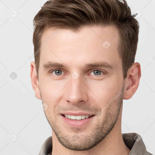 Joyful white young-adult male with short  brown hair and grey eyes