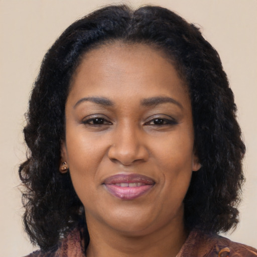 Joyful black adult female with long  brown hair and brown eyes