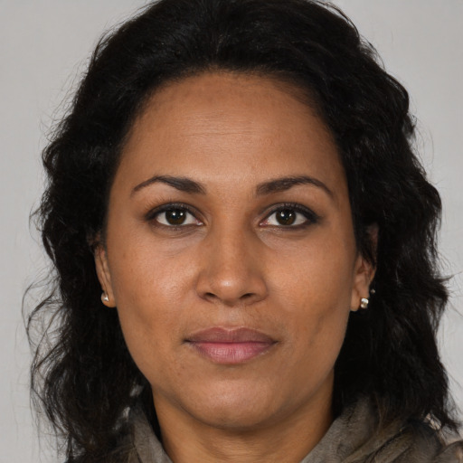 Joyful black adult female with long  brown hair and brown eyes