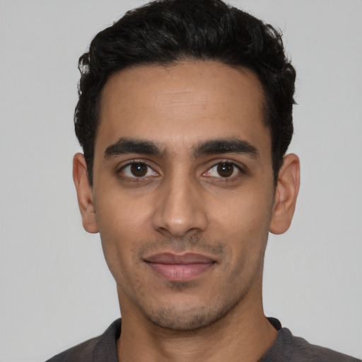 Joyful latino young-adult male with short  black hair and brown eyes