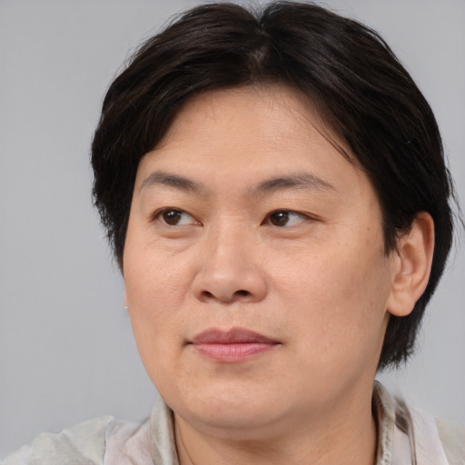 Joyful asian adult female with medium  brown hair and brown eyes