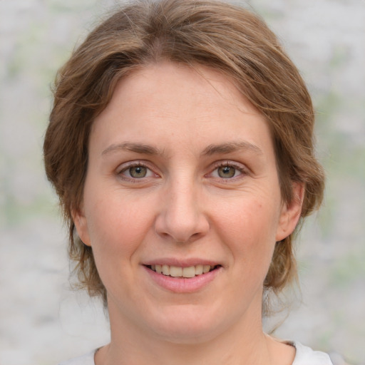 Joyful white young-adult female with medium  brown hair and green eyes