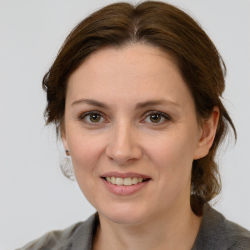 Joyful white young-adult female with medium  brown hair and grey eyes