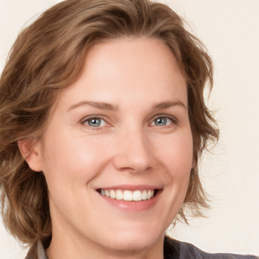 Joyful white young-adult female with medium  brown hair and blue eyes