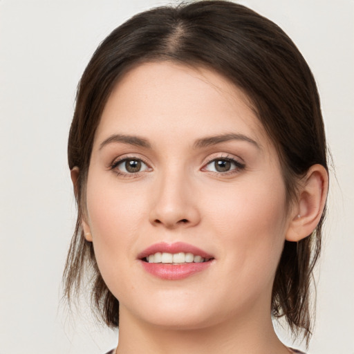 Joyful white young-adult female with medium  brown hair and green eyes