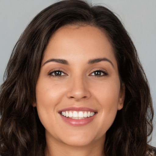 Joyful white young-adult female with long  brown hair and brown eyes