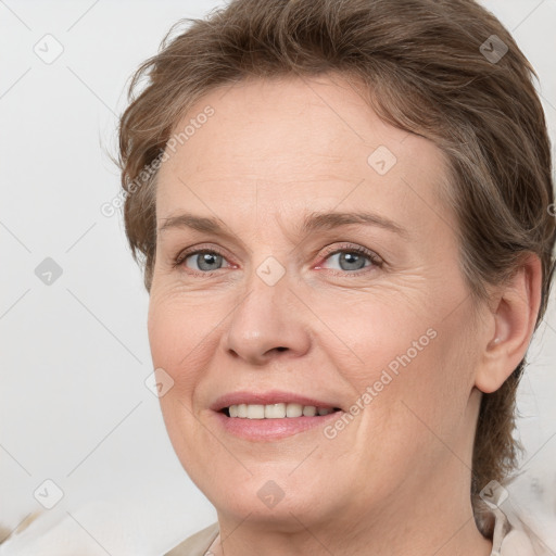 Joyful white adult female with medium  brown hair and grey eyes