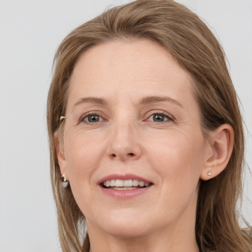 Joyful white adult female with long  brown hair and grey eyes