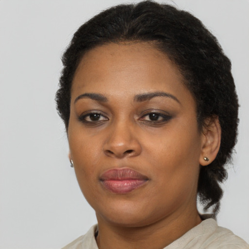 Joyful black young-adult female with long  brown hair and brown eyes