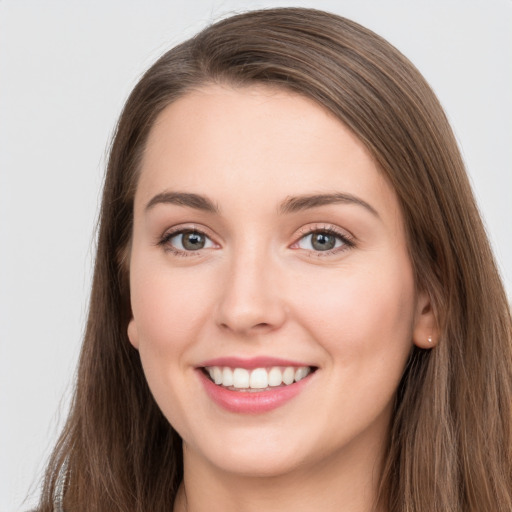 Joyful white young-adult female with long  brown hair and grey eyes