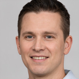 Joyful white adult male with short  brown hair and brown eyes