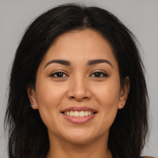 Joyful latino young-adult female with long  brown hair and brown eyes