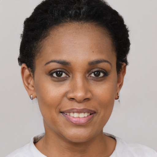 Joyful black young-adult female with short  brown hair and brown eyes