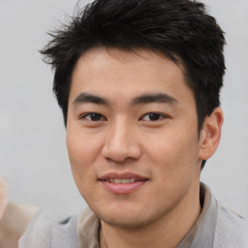 Joyful white young-adult male with short  black hair and brown eyes