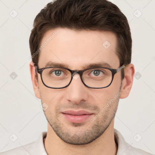 Joyful white young-adult male with short  brown hair and grey eyes