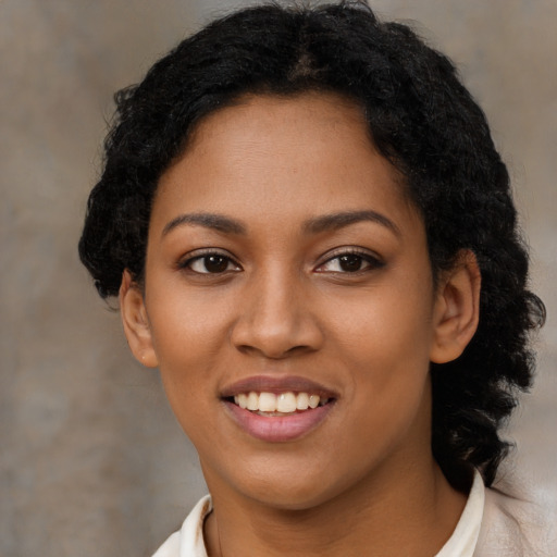 Joyful black young-adult female with long  black hair and brown eyes