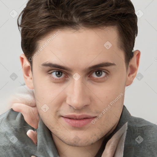 Joyful white young-adult male with short  brown hair and grey eyes