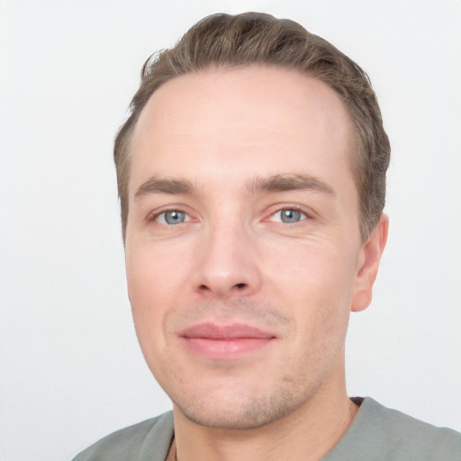 Joyful white young-adult male with short  brown hair and grey eyes