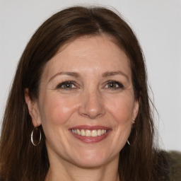 Joyful white adult female with long  brown hair and grey eyes