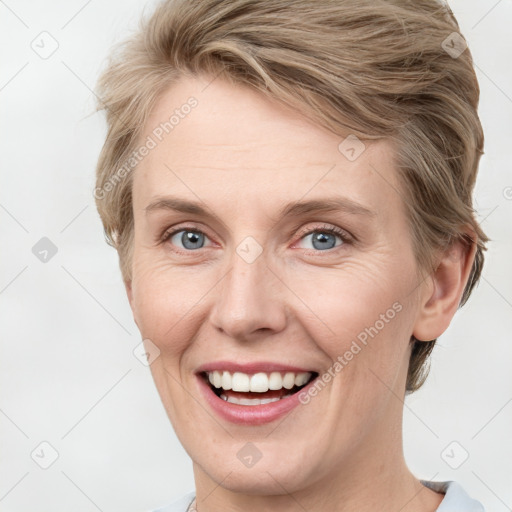 Joyful white adult female with medium  brown hair and blue eyes