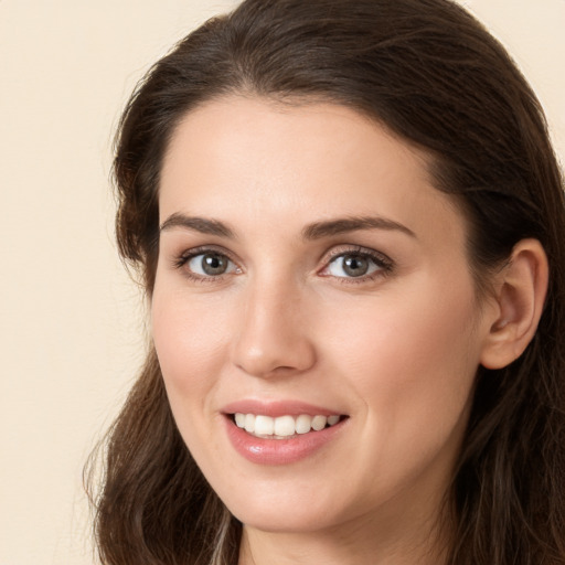 Joyful white young-adult female with long  brown hair and brown eyes