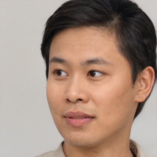Joyful asian young-adult male with short  brown hair and brown eyes