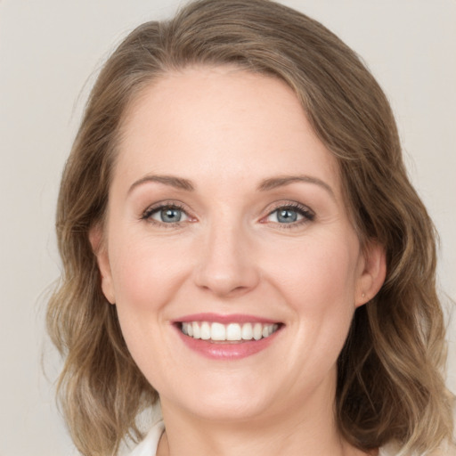 Joyful white young-adult female with medium  brown hair and green eyes